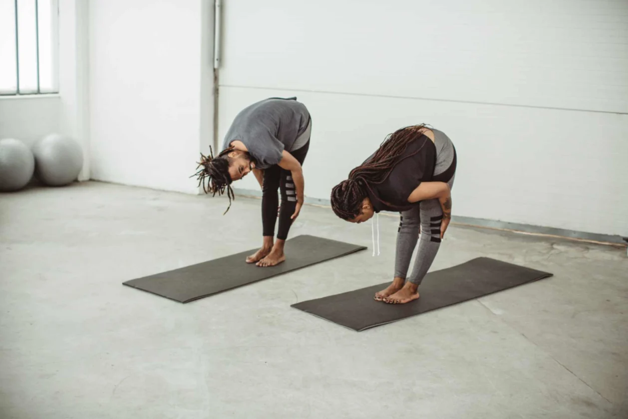 Couple practicing somatic yoga forward fold